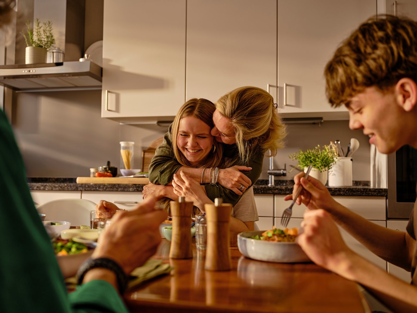 Familie spiser middag sammen rundt kjøkkenbordet, fra HelloFresh Familie spiser middag sammen rundt kjøkkenbordet, fra HelloFresh
