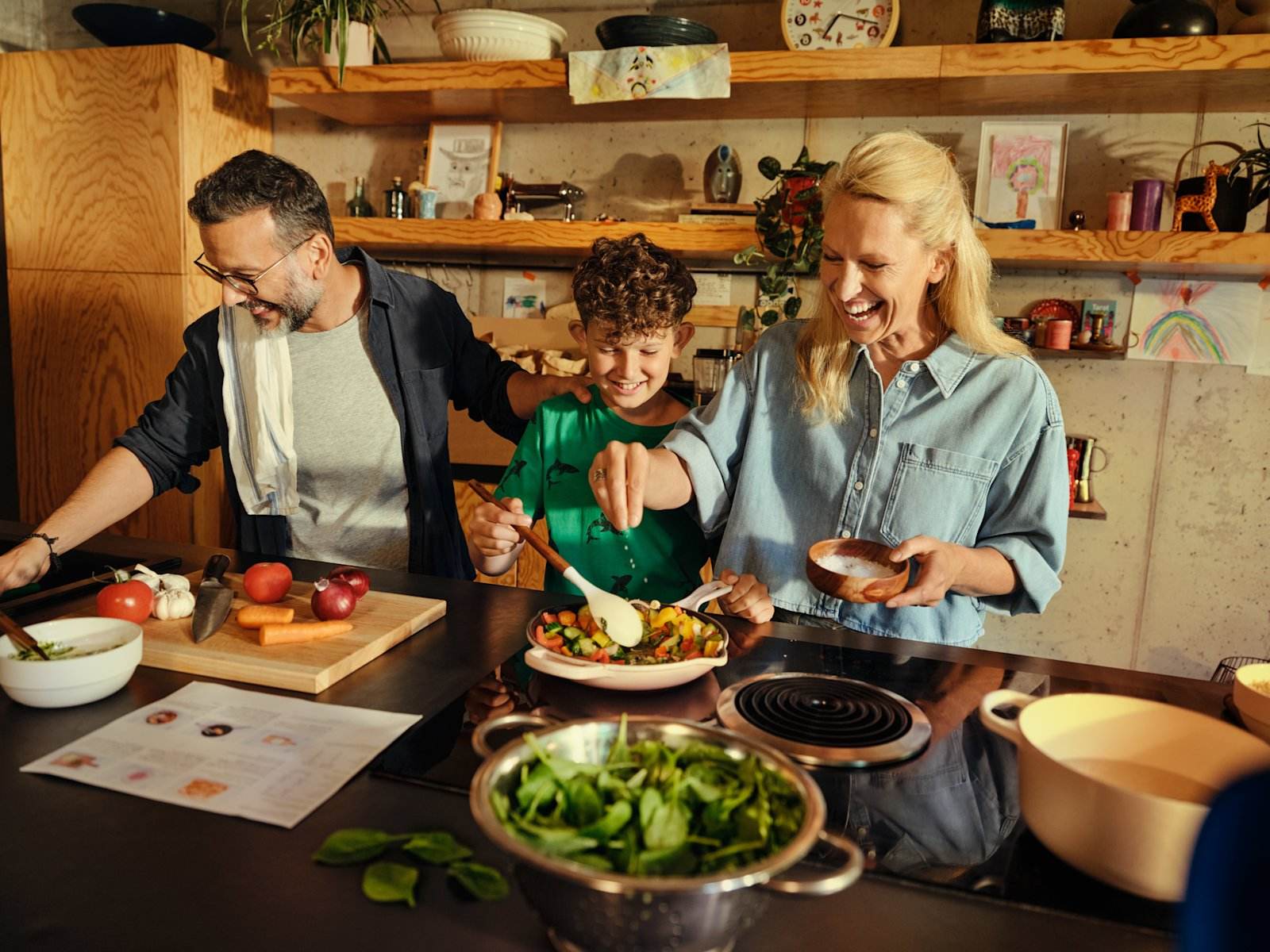 Familie lager middag sammen på kjøkkenet med råvarer fra HelloFresh
